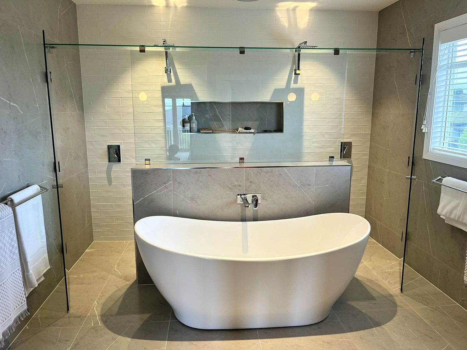 Bathroom with freestanding bath and frameless shower screen