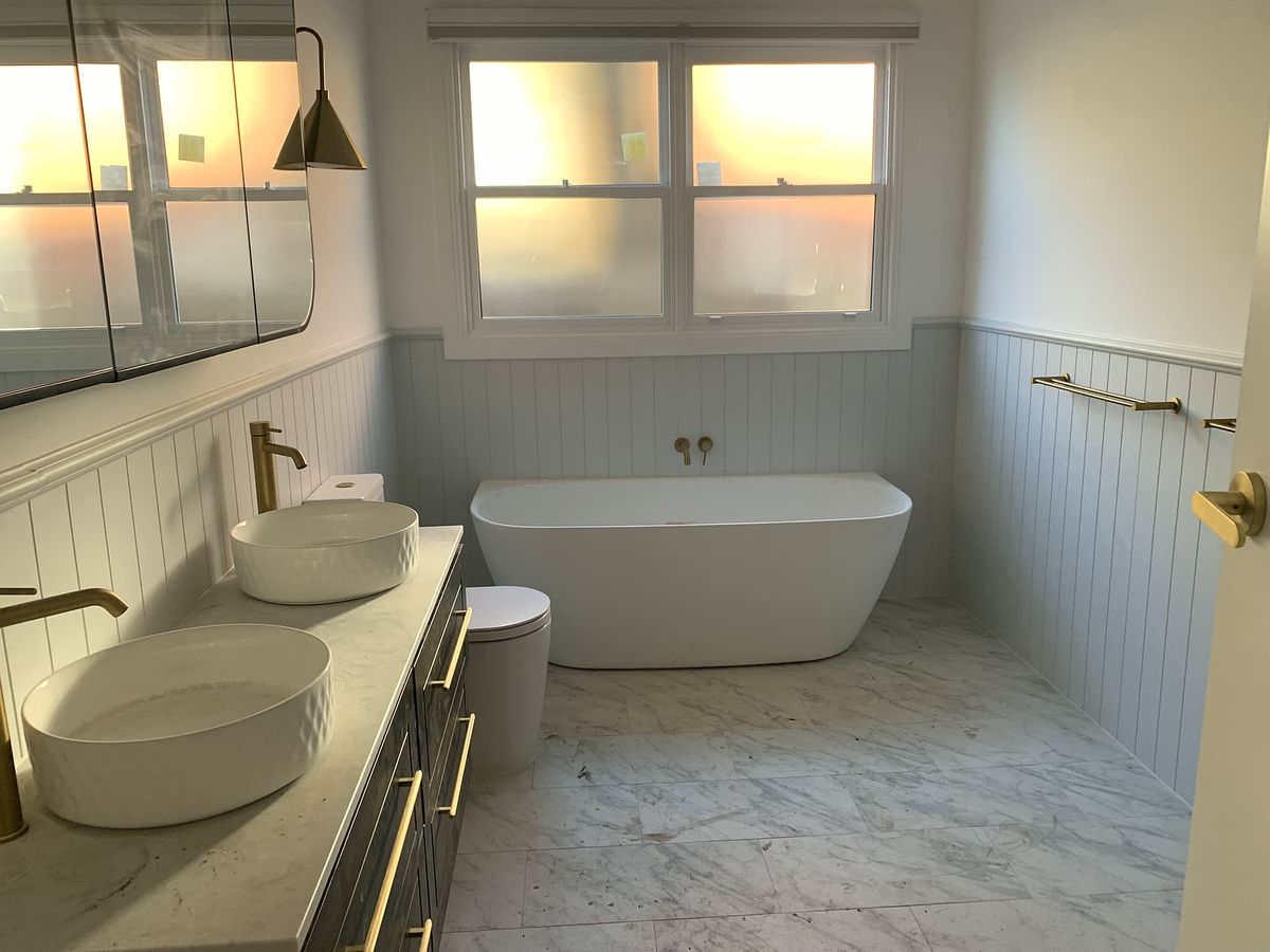Family bathroom with brass tapware, twin basins and freestanding bath
