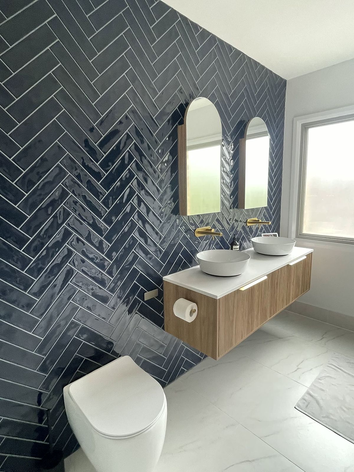 Bathroom with navy herringbone feature wall and floating timber vanity