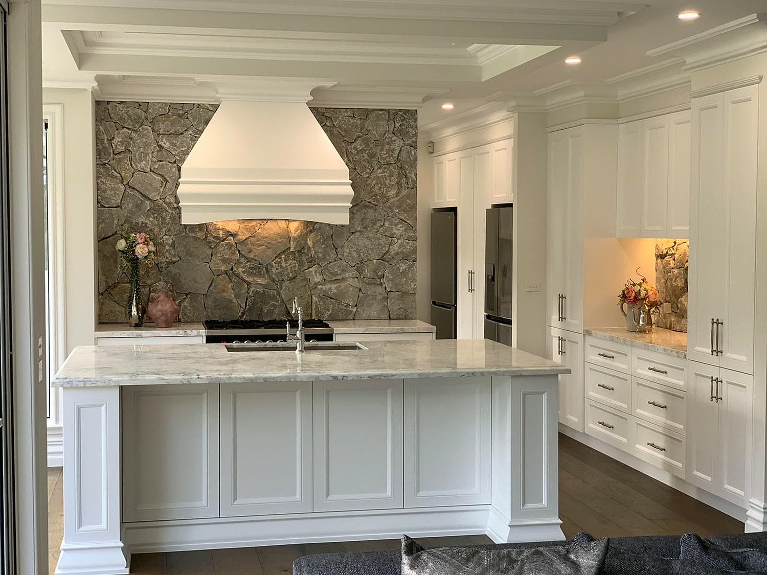 Hamptons style kitchen with stone splashback and mantle range hood