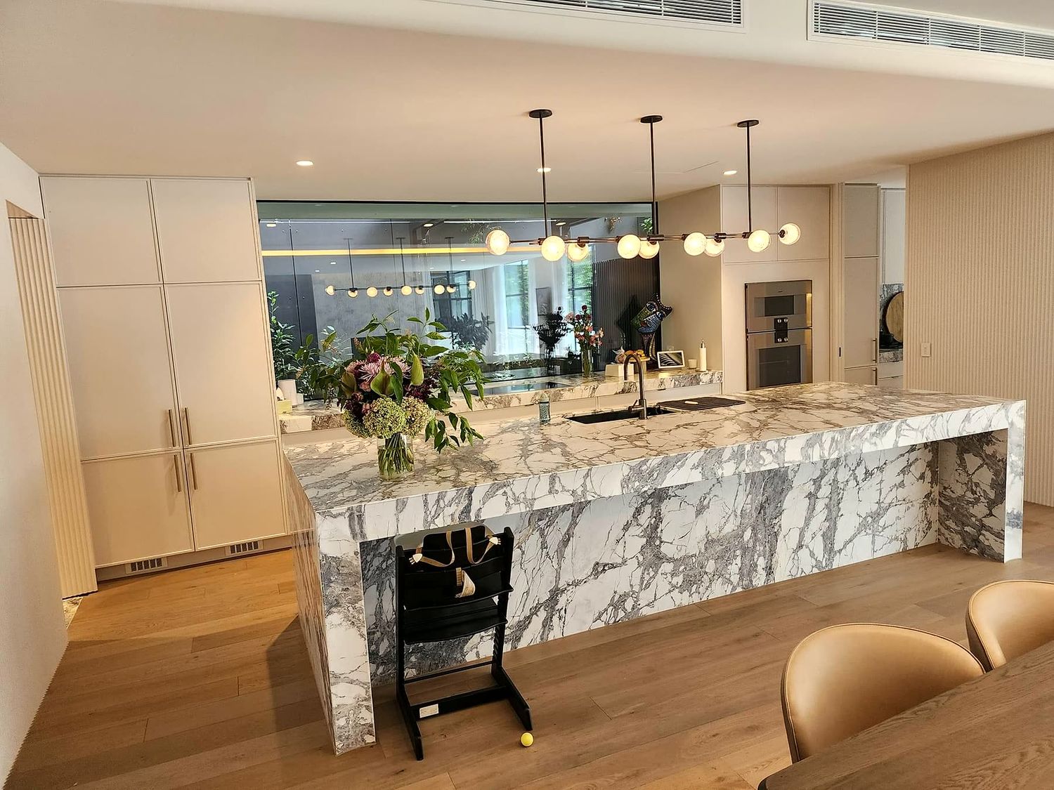 Kitchen with a marble waterfall island and pendant lighting