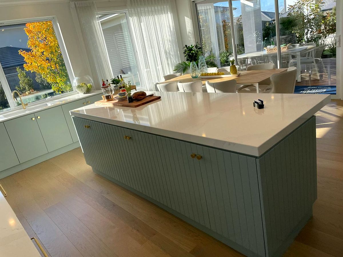 Sage green island kitchen with stone benchtop