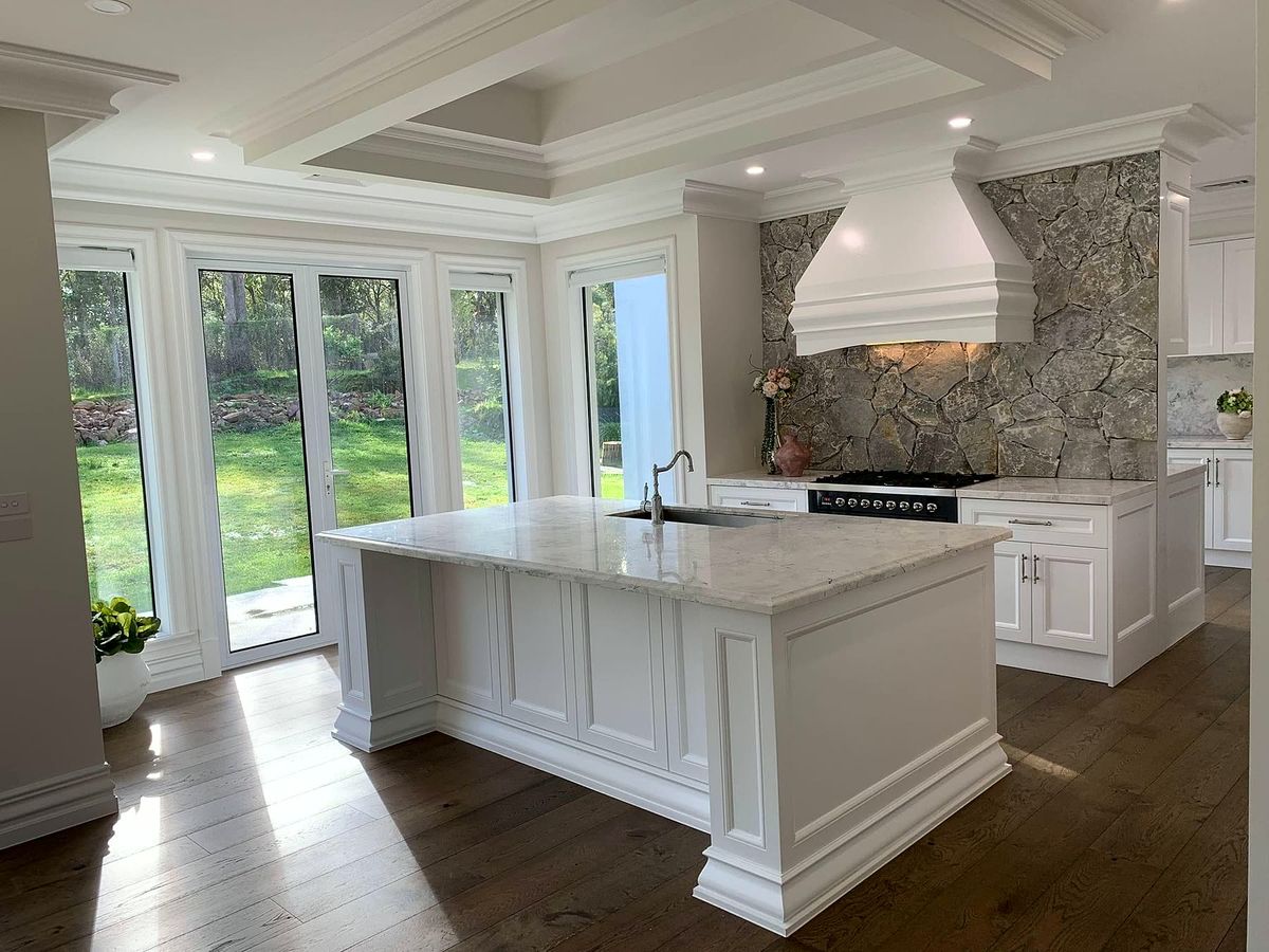 White shaker kitchen with island opening onto a garden